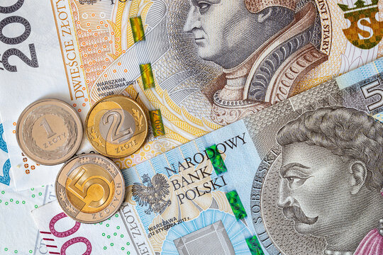 Polish zloty coins rest on top of 200 and 500 zloty banknotes. Polish national currency PLN. European finance.