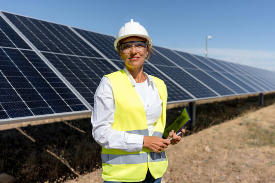 Female engineer inspect solar panel at renewable energy site