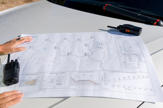 Female engineer planning wind turbine field with site plan