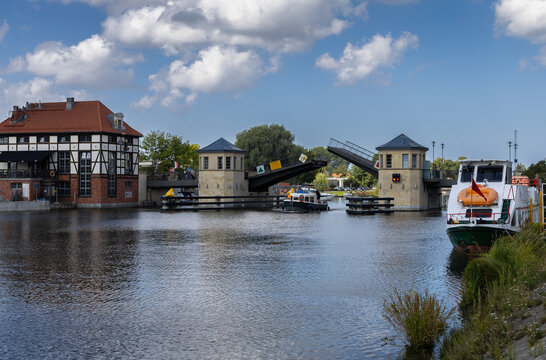 A boat passing under an open bridge. "High Bridge," Elbląg, Poland.