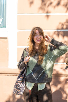 Smiling woman in argyle sweater with zebra print bag