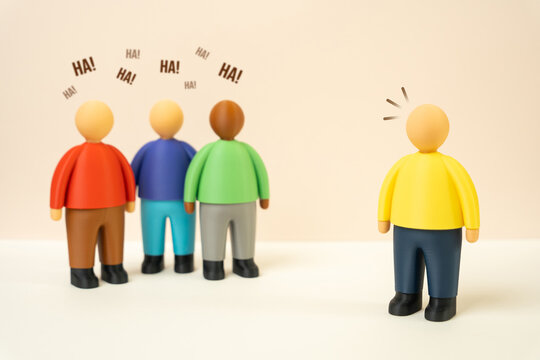 Group of people mocking a person, ridicule and humiliating comments directed at an individual. Public humiliation and workplace bullying can damage confidence. Mental wellbeing and social inclusion
