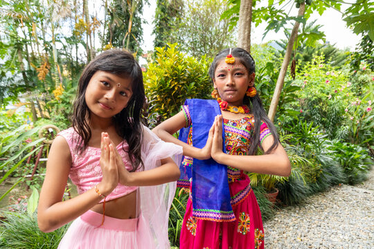 Young girls perform namaste gesture in traditional dress