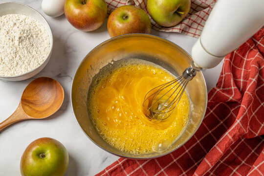 Homemade apple pie preparation with whisked egg mixture