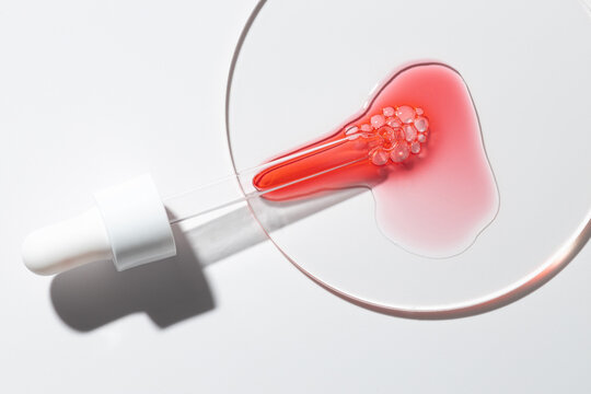 Red acid peel serum in petri dish with sharp shadow