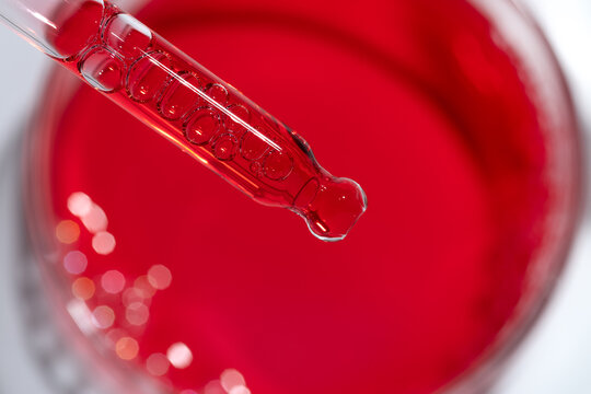 Cosmetic science dropper with bubble texture over red liquid