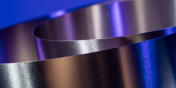 Abstract metal ribbon curve with blue and purple light