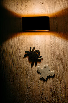 Halloween spider and ghost silhouette on textured wall