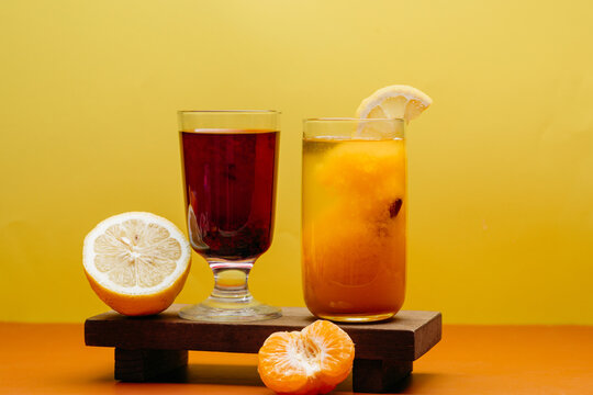 Tea and citrus drinks with fresh fruit on yellow background