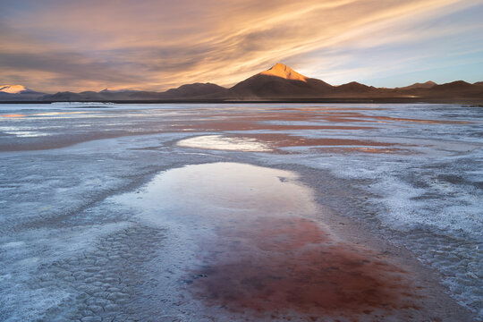 Sunrise over salt flat and Andean mountain landscape