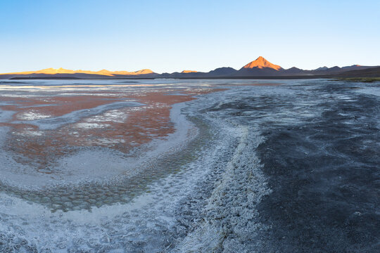 Sunrise over salt flat and Andean mountain landscape