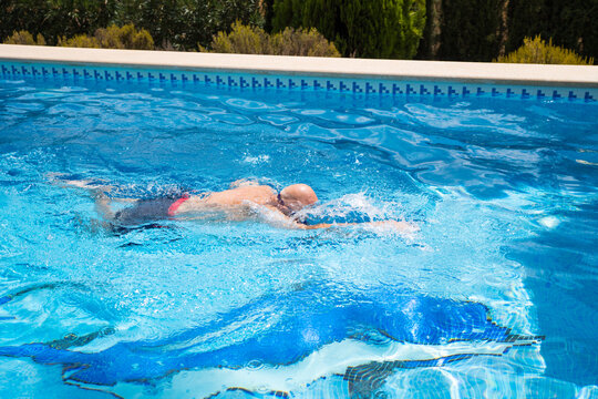Senior man swim freestyle in outdoor pool