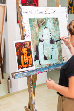 Woman painting portrait during art lessons in studio