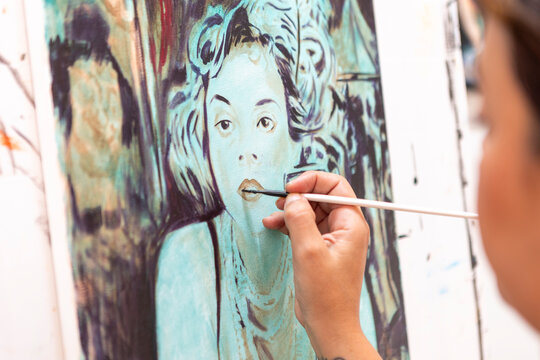 Woman painting portrait during art lessons in studio