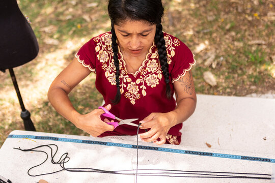 Artisan creates handmade macrame cord craft outdoors