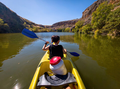 Kayaker paddling through Duraton river canyon near Segovia