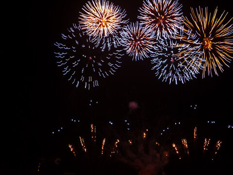 Colorful fireworks burst over dark night sky celebration