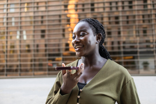 Black woman use smartphone voice message outdoors