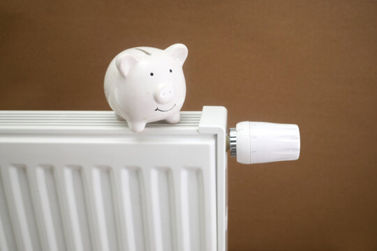 Piggy bank on radiator saving heating energy costs