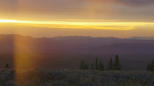 Layered ridges in golden yellow and violet sunset haze, time lapse, Utah