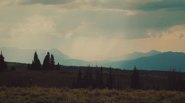 Rainstorm over teal mountains above yellow green sagebrush, time lapse, Utah