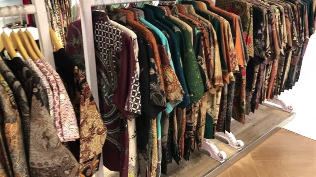 Panning Shot Across Batik Shirts Hanging on a Retail Rack