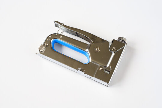 Metal construction stapler tool isolated on white background.  Professional hand tacker hardware for carpentry work and home renovation, furniture repair and upholstery, stretching canvas