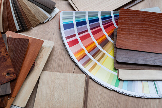 Top View of Wooden Laminate Swatches and Paint Palette Guide for Furniture Production Workspace