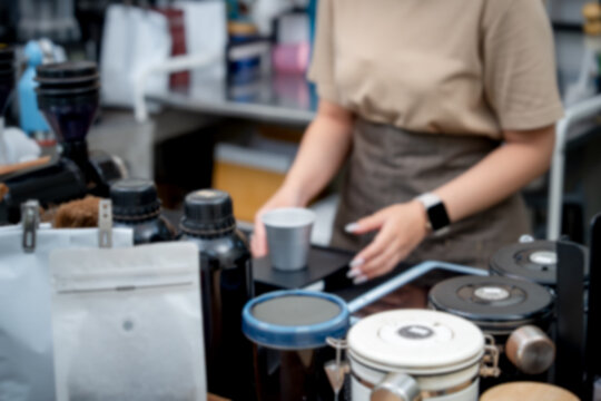 Soft focus coffee shop background with equipment and worker hands, perfect for website headers.