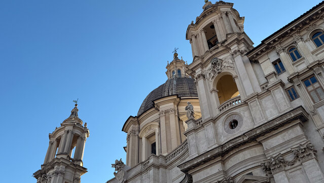 Baroque church dome and bell tower of Sant'Agnese in Agone against a blue sky, Piazza Navona, Rome, Italy