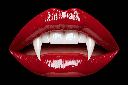 Close-up of glossy red lips with vampire fangs bared, Halloween beauty portrait