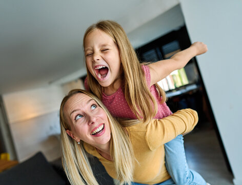 Portrait of mother and daughter having fun at home, family life, parenting, love and bonding concepts