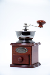 Retro style wooden hand coffee mill with stainless steel hopper and pull-out drawer standing on white background with negative space, traditional barista equipment for cafe menu © Wicee