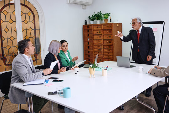 diverse business group of adult people working together and using laptop at office. Successful hispanic Entrepreneurs multigenerational and multicultural teamwork in workplace