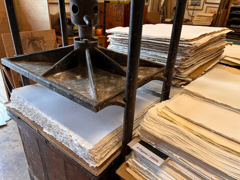 Antique paper press with stacks of aged documents in heritage workshop
