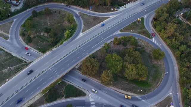 Aerial Timelapse of City Highway Interchange with Cars and Lush Greenery