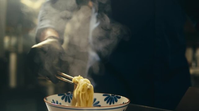 Ramen bowl with noodles served in Japanese restaurant, chef putting fresh noodles into hot soup bowl, traditional asian ramen dish with broth and toppings