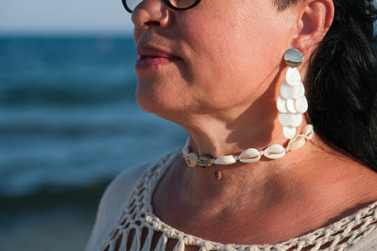 closeup of a mature woman face with pearl earrings