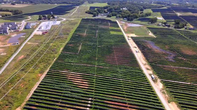 Solar farm infrastructure and nearby houses enter a rightward aerial panorama across Virginia.