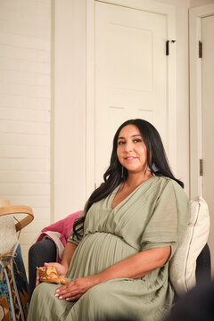 Native American pregnant woman sits indoors waiting for her baby