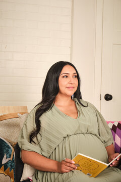 Native American pregnant woman reading in a home setting