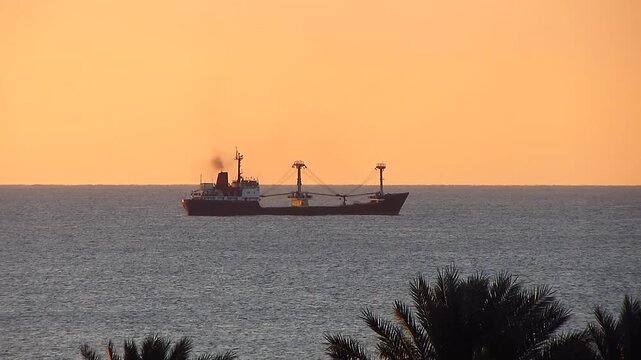 Cargo ship sailing in the Red Sea during sunris