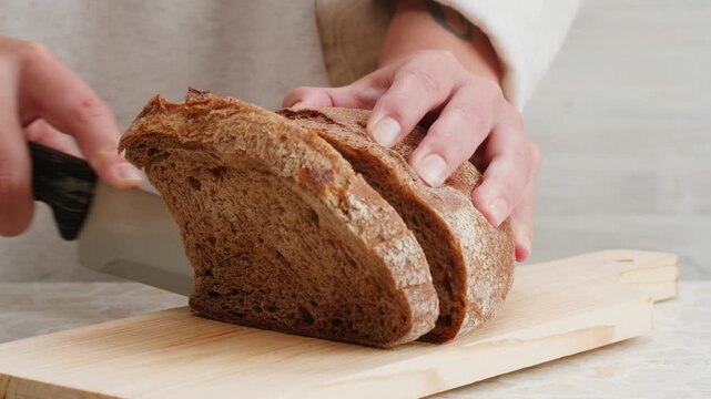 Black rye bread close up, dark brown sliced loaf, borodinsky slavic food, square slices with coriander on white background