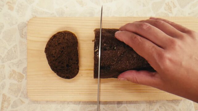 Black rye bread close up, dark brown sliced loaf, borodinsky slavic food, square slices with coriander on white background