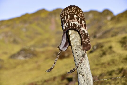 Chullo, traditional Peruvian cap fluttering in the wind on a post, Andes, near Cusco, Peru, South America