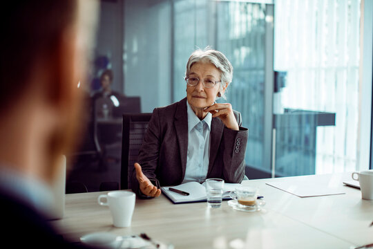 Senior businesswoman listening during job interview in office
