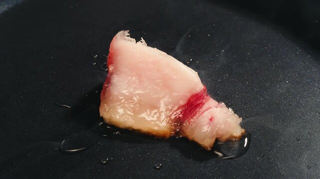 Lamb fat tail raw piece close up, white sheep lard fat on wooden board, unhealthy fatty food high in cholesterol and saturated fat