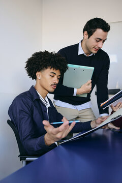 Young latin teamwork of men working at office and using laptop in Latin America, Hispanic business people at workplace