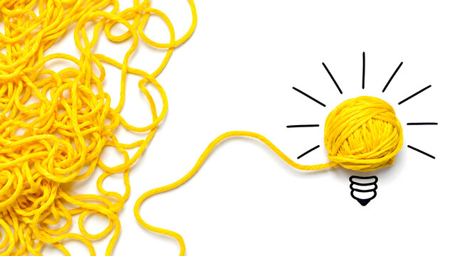 Tangled yellow yarn unwinding into a bright lightbulb shape on white background representing problem solving and creative ideas
