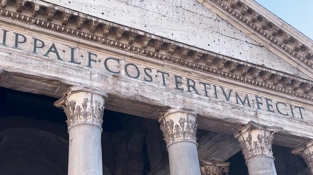 Weathered Latin letters carved on the pediment frieze above the Pantheon portico, Rome, Italy